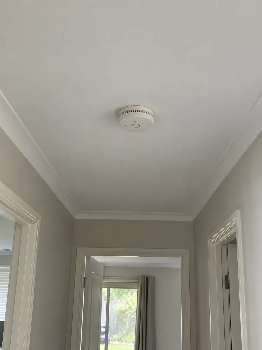 Ceiling-mounted smoke alarm in a hallway