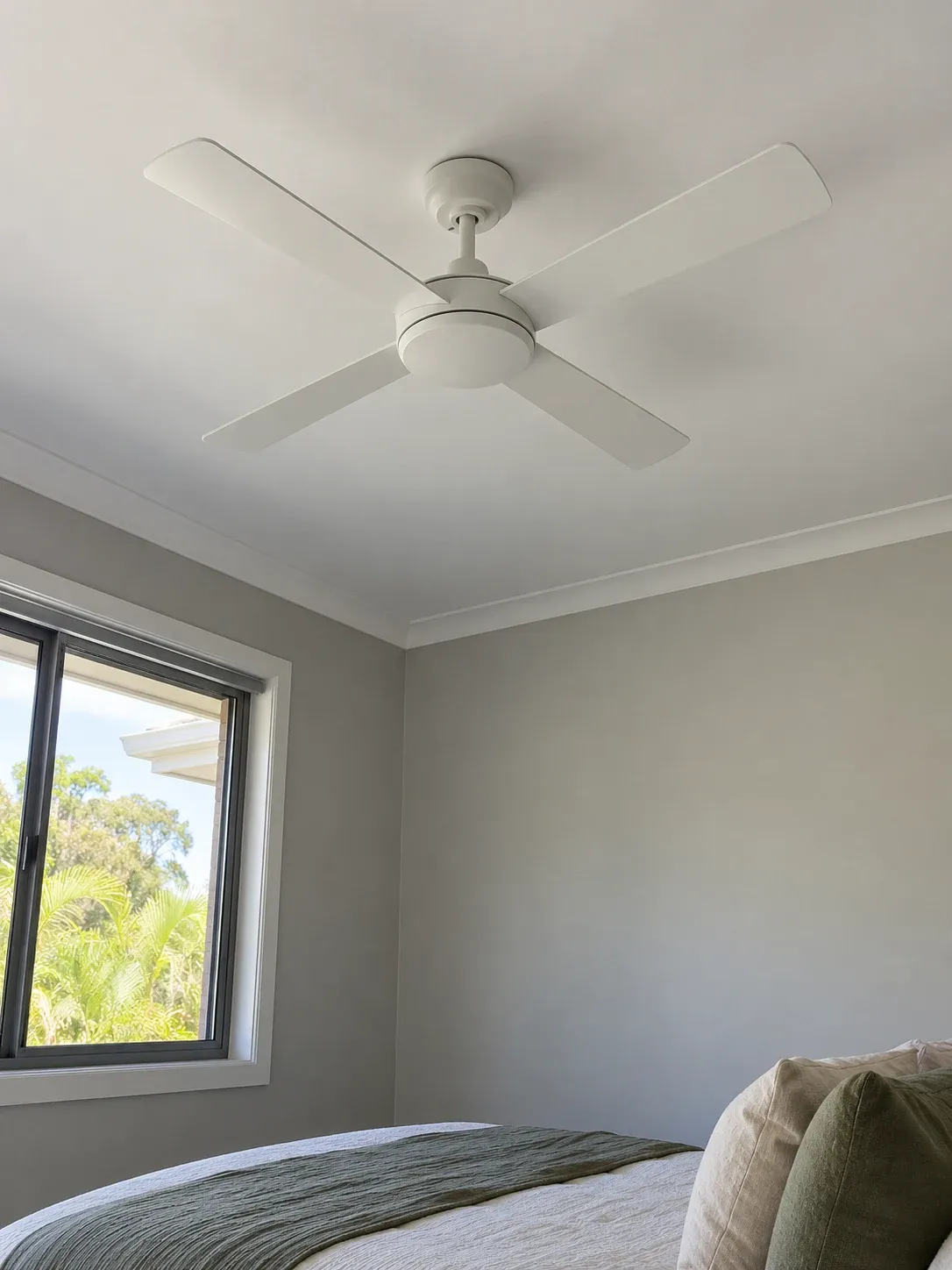 White four-blade ceiling fan in a bedroom