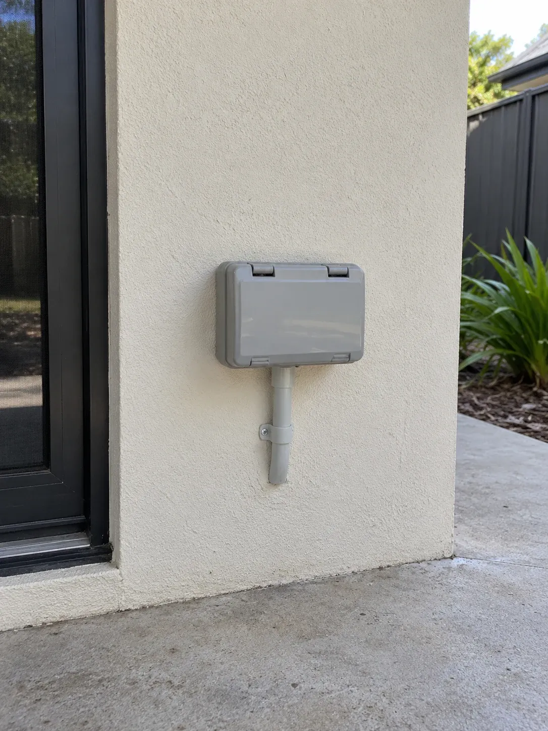 Closed weatherproof outlet enclosure on an exterior wall