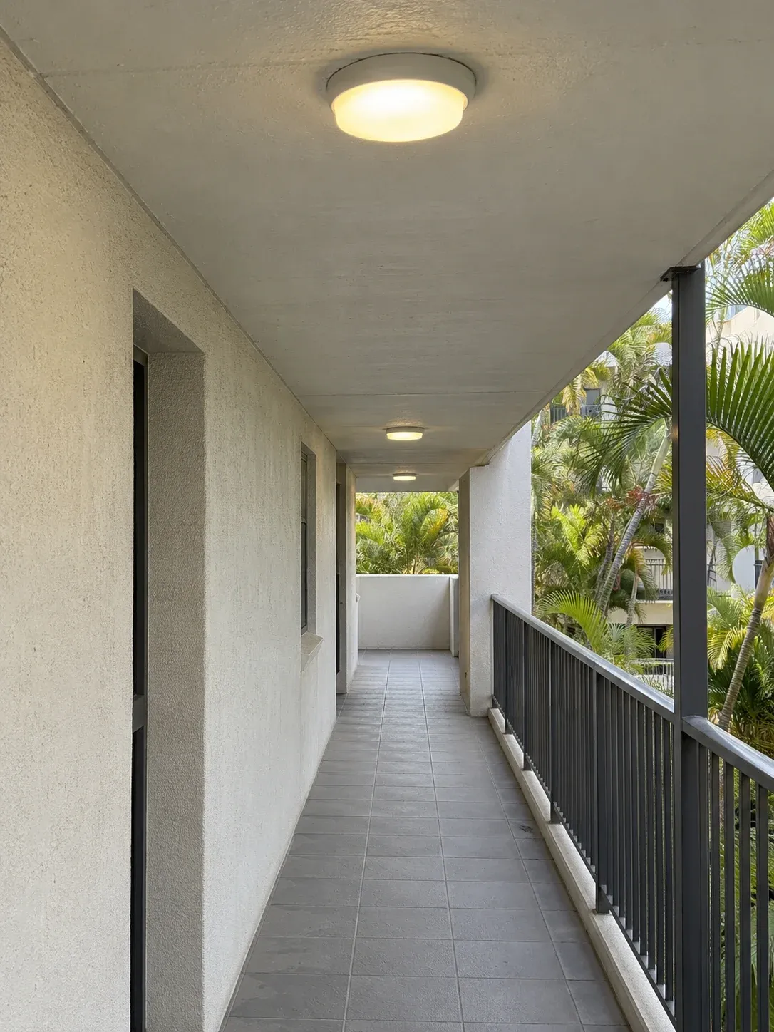 Ceiling lights along a covered apartment walkway